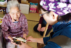 弁当を受け取る金谷松代さんの写真