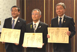 表彰状を持った平井頭取、亀井副知事、山崎頭取の写真