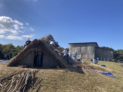 修理が進む妻木山地区の竪穴住居と高床倉庫(右)の覆屋