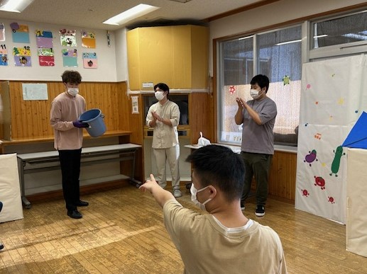 親睦会にてゲームの説明を聞いている様子