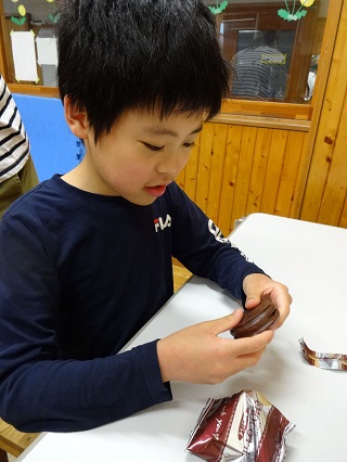 チョコレート菓子を食べる児童