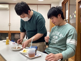 職員がホットケーキを切り分ける写真