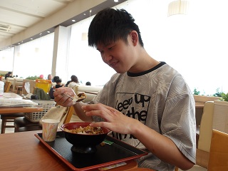 うな丼を笑顔で食べる児童