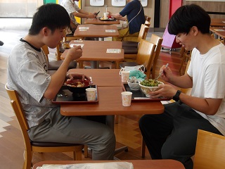 向かい合わせで食事を摂る児童と職員