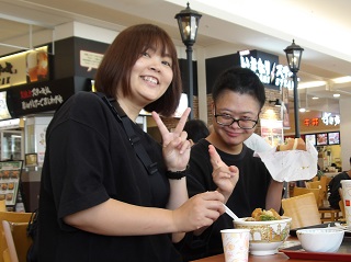 食事を前にピースする児童と職員