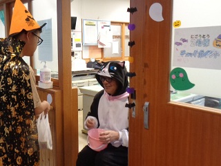 化け猫の仮装をした職員と魔法使いの仮装をした子どもが並んでいる