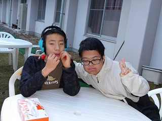 肩を組んでピースをする二人の児童