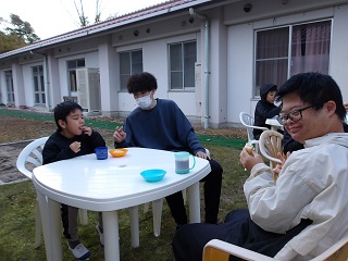 職員と児童がテーブルを囲んでピースをしている