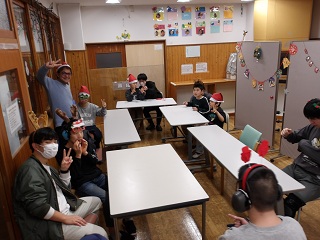 集会室に集う児童と職員