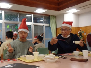 スープカップを片手に微笑む児童と職員