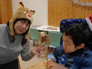 トナカイの被り物をした職員と児童