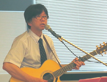 ギターを手に歌う石川さん