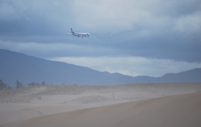 砂丘上空を飛ぶジャンボ機